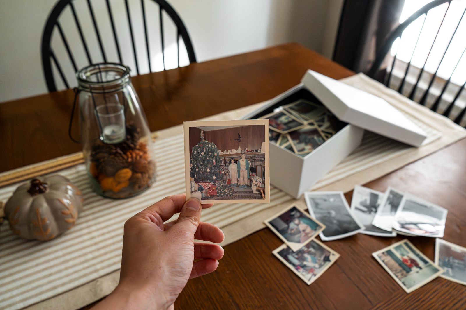 A box of old family photos on a dining table