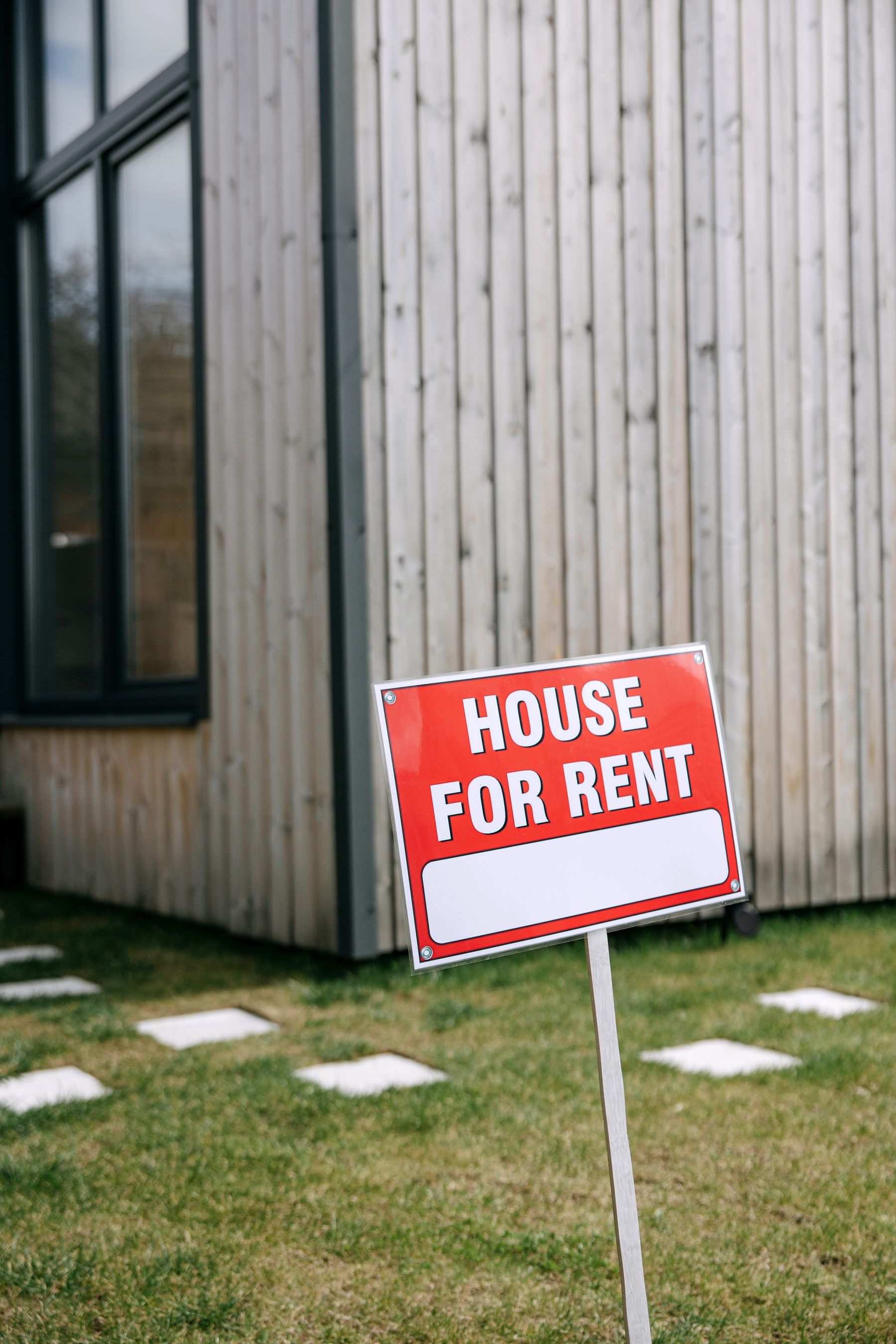 A house for rent sign in front of a house